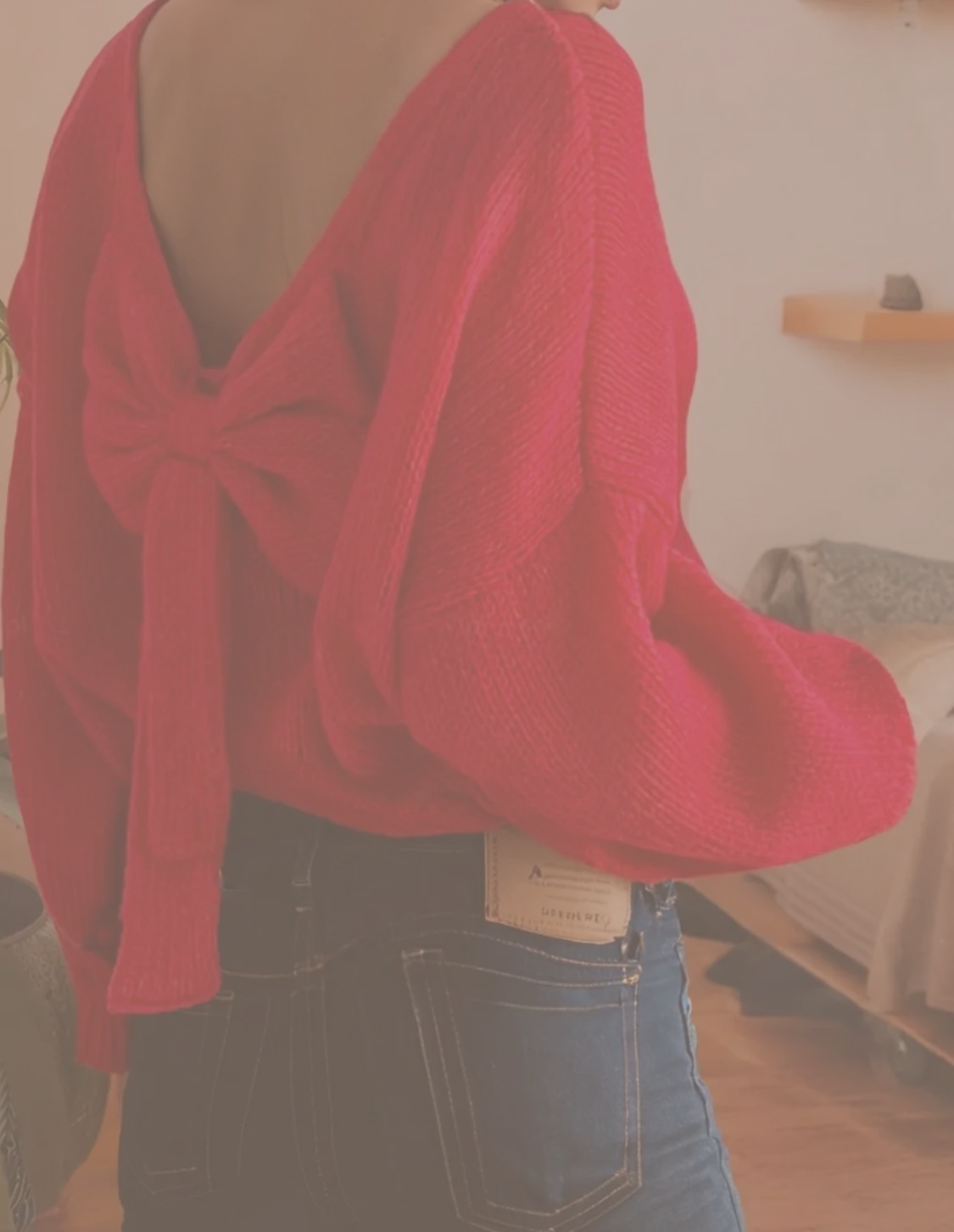 Woman wearing red sweater with bow on the back