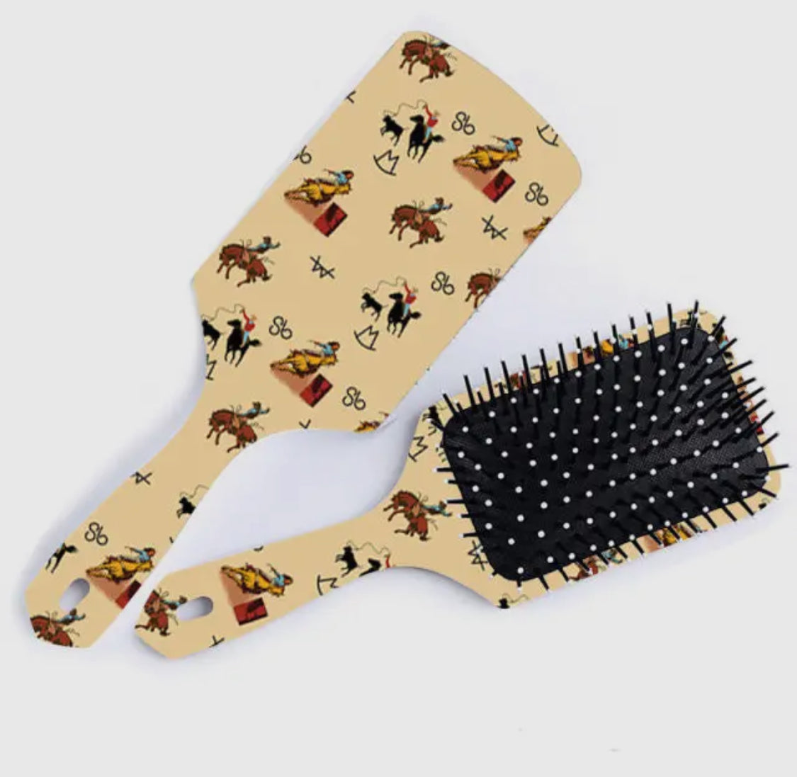 Paddle and brush hair styling tools with cowboy pattern on beige background