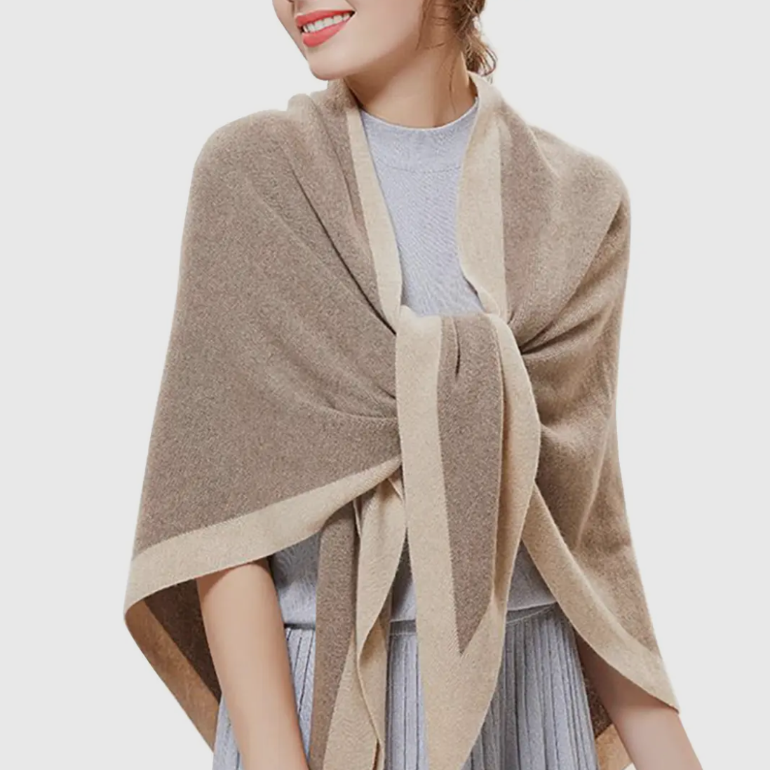 Woman wearing a beige shawl over a light gray outfit on a white background